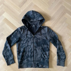 Polo Ralph Lauren hoodie - Snygg hoodie från Polo Ralph Lauren i grått och svart camomönster. Tröjan är i mycket bra skick. Hör gärna av er för fler bilder eller funderingar😇✌️