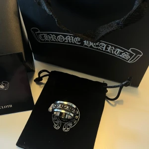 Silverring från Chrome Hearts - Silverring från Chrome Hearts med detaljerade korsmönster runt om. Ringen har en tydlig logotyp ingraverad på insidan. Kommer med originalpåse och ask. Pris går att diskutera och fråga bara på frågor!😊