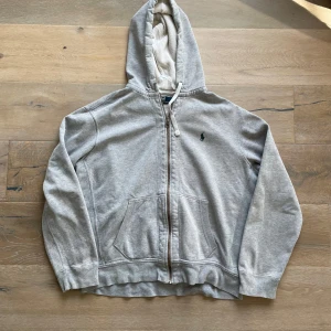 Polo Ralph Lauren zip hoodie - En riktigt snygg grå polo ralph lauren zip hoodie med grönt märke i storlek L i bra skick. Nypris: 2499 kr mitt pris: 499 kr hör av er vid frågor pris kan diskuteras