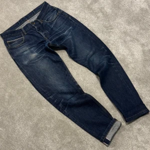 Selvedge Jeans - Tja! Säljer dessa riktigt feta mörkblå Selvedge jeansen med sjukt snygg tvätt! Jeansen är i fint skick, en lagning i skrevet men det märks inte, se bild 4. Passar 32/32. Midjemått: 42cm, ytterbenslängd: 103 cm. Straight passform. Skriv vid funderingar!