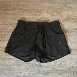 Svarta träningsshorts - Svarta shorts från Intersport med resår och snörning i midjan. Använda fåtal gånger.