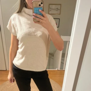 Beige stickad polotopp - Säljer en beige stickad T-shirt med krage. Storlek L men massar som S. Köpt på Lindex.