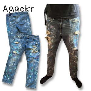 Blå jeans med färgstänk och slitningar från Polo Ralph Lauren - Unika blå jeans med färgstänk i olika nyanser och slitna detaljer på benen. Klassisk femficksmodell med knappgylf och låg midja. Märke: Polo Ralph Lauren. 34/34🙏