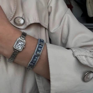 Blått armband med stjärndetaljer - Unikt armband i ljusblått återvunnet jeansmaterial som även är handgjort och dekorerat med silverfärgade metalldetaljer i rostfritt stål. Armbandet har en justerbar kedja för perfekt passform och själva jeansdelen är 16 cm lång. Denna är extra stor i storleken men vi anpassar den gärna så att den passar just dig. Kolla gärna in vår instagram: Jeanfluence.uf