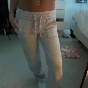 Grå mjukisbyxor med snörning - Säljer ett par grå mjukisbyxor med resår och snörning i midjan. Byxorna har fickor på sidorna och en avslappnad passform, perfekta för chill dagar hemma eller till vardags. Superbekväma och lätta att matcha med en hoodie eller crop top.