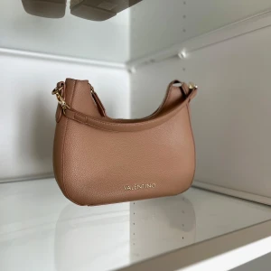 Beige axelväska från Valentino - Säljer en snygg beige axelväska från Valentino med gulddetaljer🧚‍♂️Endast använd fåtal gånger 