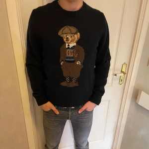Mörkblå stickad tröja med björn på från Polo Ralph Lauren - Säljer en mörkblå stickad tröja från Polo Ralph Lauren eftersom det börjar bli sommar och min kille vill ha lite nya kläder! Tröjan har rund halsringning och långa ärmar. Klassisk och stilren design med RL-broderi vid nederkanten. ❗️Ny pris är 5000kr ❗️pris går att diskutera vid snabb affär!