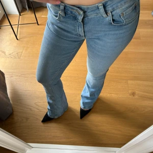 Ljusblå bootcut jeans - Säljer ett par ljusblå bootcut jeans med låg midja.