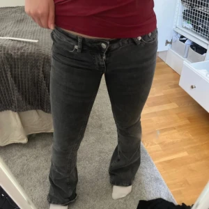 Svarta bootcut jeans - Säljer ett par svarta bootcut jeans med låg midja. Jeansen har klassisk femficksdesign och stängs med dragkedja och knapp. Perfekta för dig som gillar en lite utsvängd passform nertill.