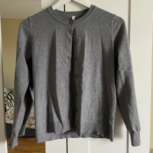 Grå kofta med knappar - En klassisk grå kofta med rund hals och knäppning framtill. Tröjan har långa ärmar och ribbade muddar vid ärmslut och nederkant. Perfekt att slänga på sig över en t-shirt eller blus, jätte fin och skön💘😚