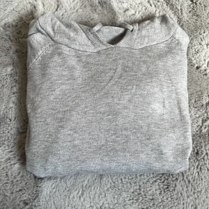 Grå hoodie i merinoull från Verani - Säljer en enkel och stilren grå hoodie med huva och dragsko. Tröjan har långa ärmar och ribbade muddar vid ärmslut och nederkant. Perfekt för en avslappnad look. Nypris 800. Hör av er vid frågor! Kan tänka mig och sänka priset också.