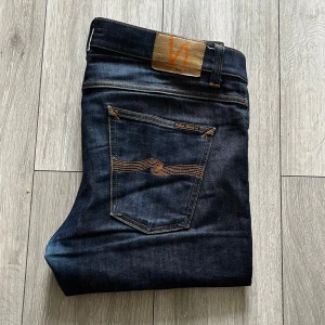 Nudie jeans - Säljer dessa snygga nudie jeans i mörkblå färg och som är storlek W33 L34. De är perfekt för en bekväm look och de är i 9,5/10 i skick. Ny pris är 1399kr Kontakta vid funderingar.