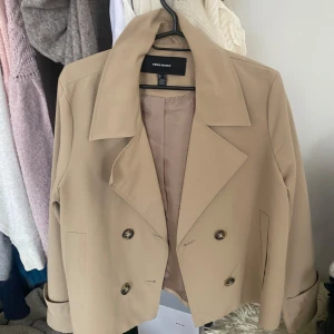 Trenchcoat  - Snygg beige trenchcoat från Vero Moda. Aldrig använd