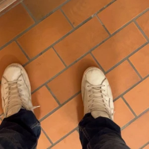 Vita sneakers från Philippe Model - Säljer ett par stilrena vita sneakers från Philippe Model. Skorna har klassisk design med rund tå, platt sula och snörning. Tillverkade i skinn för en lyxig känsla och passar perfekt till jeans eller andra vardagsoutfits.