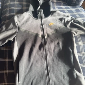 Svart hoodiejacka från Nike - Säljer min Nike teech fleece. Det är og colourway och jag köpte den för två år sedan. Jag använde aldrig den och den är i helt ny skick 
