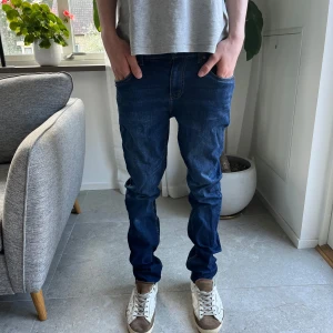 Levi's 512 Slim Taper jeans i mörkblå denim - Säljer ett par Levi's 512 Slim Taper jeans i mörkblå denim. Jeansen har klassisk femficksdesign, dragkedjegylf och smal passform som smalnar av nedtill. Perfekta för dig som gillar en modern och stilren look.