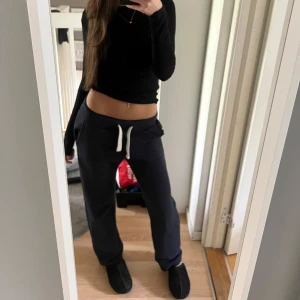 Mörkblåa mjukisbyxor med vit dragsko - Säljer ett par mörkblåa mjukisbyxor med vit dragsko i midjan. Byxorna har en loose passform och raka ben, perfekta för en avslappnad stil. Mjukt material och bekväma fickor på sidorna. Ord pris: 499