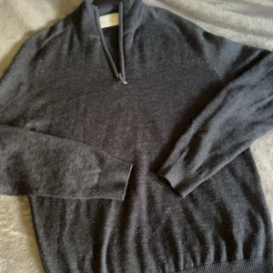 Mörkgrå halvzip-tröja från Bruun & Stengade - Säljer en stilren mörkgrå långärmad tröja från Bruun & Stengade i storlek M. Använd få gånger