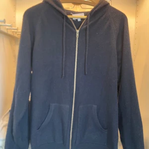 Davida cashmere hoodie - Säljer en enkel och stilren mörkblå hoodie med dragkedja och huva. Tröjan har två fickor framtill och justerbara snören vid huvan. Perfekt för en avslappnad look. Davida Kashmir hoodie knappt Andvänd bra skick 