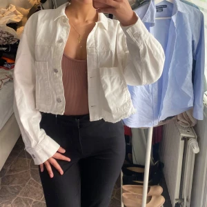 Vit croppad jeansjacka - Säljer en vit croppad jeansjacka med knappar framtill  i storlek M 