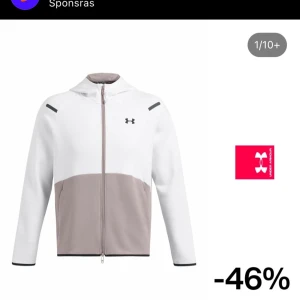 Vit och beige zip-hoodie från Under Armour - Snygg hoodie med dragkedja från Under Armour i vitt och beige. Jackan har huva, lång ärm och en minimalistisk design med logga på bröstet. Perfekt för träning eller chill.