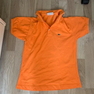 Orange Lacoste piké  - Väldigt lite använd och bra skick. Kom dm för fler bilder 