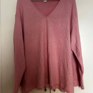Rosa stickad v-ringad tröja - Mysig rosa stickad tröja med v-ringning och långa ärmar. Perfekt för lager-på-lager och passar till både jeans och kjol. Enkel och stilren design som är lätt att matcha.