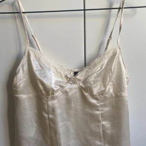 Vit satinlinne med spetsdetaljer - Krämvitt linne. Storlek 36. Aldrig använd men lappen är borta. 