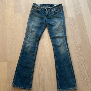 Blå bootcut jeans från MCS - Säljer ett par klassiska blå bootcut jeans från MCS i storlek w28. Jeansen har lätt slitna detaljer, fem fickor och en snygg tvätt. Perfekta för dig som gillar en tidlös jeanslook med lite vidare ben.
