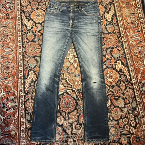 Blå Nudie jeans! - Säljer sjukt snygga blå nudie jeans med en otrolig wash! De har en lagning men den syns ej vid användning!Dessa är modellen thin finn. Midja:38,5 längd:103