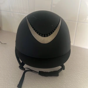JH collection ridhjälm MIPS - Säljer denna Mips ridhjälm då jag har slutat rida. Den är använd ett fåtal gånger och har aldrig ramlats av med, den har en liten repa på framsidan från att jag råkade dra med en hovkrats över den men annars har den inga defekter. Storlek 58-60 💕Pris går att diskutera, hör gärna av er innan köp