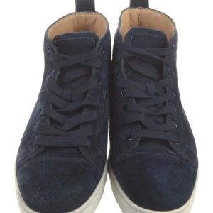 Mörkblå mocka sneakers från Christian Louboutin - Säljer ett par mörkblå sneakers i mocka från Christian Louboutin med klassisk röd sula. Skorna har snörning, rund tå och vit platt sula. Perfekta för dig som gillar stilrena och exklusiva sneakers.