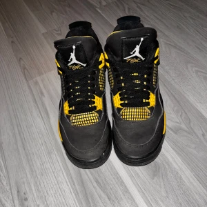 Jordan 4 retro thunder 40,5 - Den är storlek 40,5. Det finns lite slitage på ett av  sidonäten men inget man ser då det är inåt och inte utåt (kan skicka bild). Finns också några mindre missfärgningar från användning och repor på t.ex lace holdern och omkring Jordan loggan i bak men annars är den väldigt bra och riktigt skön. Suede materialet är rätt så bra och insidan av skon är fräsch. Luftenheten är hel och har inga hål eller sprickor. Dessutom är de riktiga och kan skicka bevis vid efterfrågan. 