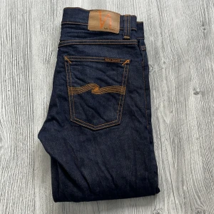 Mörkblå Nudie Jeans - Säljer ett par mörkblå jeans från Nudie Jeans med klassisk femficksdesign och kontrastsömmar. Ny pris 1299 men säljer dom här på plick För endast 399 ✅, kom dm vid frågor