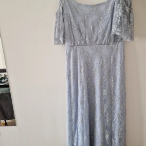 Ljusblå långklänning i spets - Säljer en elegant ljusblå långklänning Blå off shoulder lång klänning med vackert från nelly. spetsmönster och korta ärmar. Klänningen har en figurnära överdel och faller snyggt ner mot golvet. Perfekt för bal eller festliga tillfällen.  Märke: Nelly Storlek: 36 Bra skickt Helt ny, pristag på Hellt ny oanvänd
