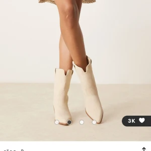 Rosatvättade/beiga cowboy boots med klack - Säljer ett par helt oanvända rosatvättade/beiga cowboy boots med klack. Skorna är tillverkade i mocka och är i storlek 40, säljer då dem var lite för stora. Köpta för 539kr, pris kan diskuteras💗