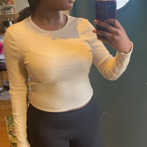 Beige ribbad långärmad topp med öppen rygg - Säljer en beige långärmad topp i ribbat material med en snygg öppen rygg. Perfekt för dig som vill ha en enkel men ändå unik topp. Sitter tajt och har rund halsringning.