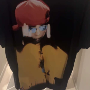 Svart Billie Eilish t-shirt med tryck - Helt oanvänd, svart t-shirt med stort tryck av Billie Eilish på framsidan och turnéstäder på baksidan. T-shirten har korta ärmar och rund hals. Inköpt på andra konserten i Stockholm ;) 