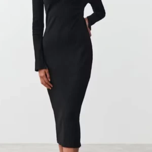 Svart ribbad långklänning med krage - Säljer en svart långklänning med ribbad struktur och lång ärm. Klänningen har en snygg krage och v-ringning som ger en stilren look. Perfekt för dig som gillar minimalistisk och tidlös stil.