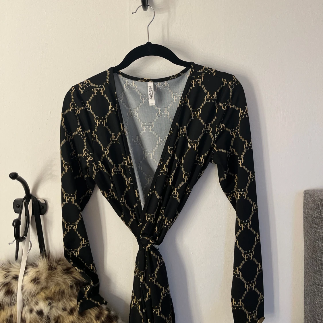 Svart omlottklänning med gulddetaljer från Chiara Forthi