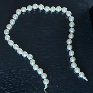 Klassiskt pärlhalsband - Säljer ett elegant halsband med stora, vita pärlor. Halsbandet har ett klassiskt och tidlöst utseende med pärlor i jämn storlek och ett diskret lås i silverfärg. Perfekt för att lyfta vilken outfit som helst.
