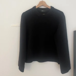 Svart stickad tröja från Gina Tricot - En klassisk svart stickad tröja från Gina Tricot. Tröjan har rund halsringning och långa ärmar med ribbade muddar. Perfekt basplagg som passar till det mesta och är enkel att styla.