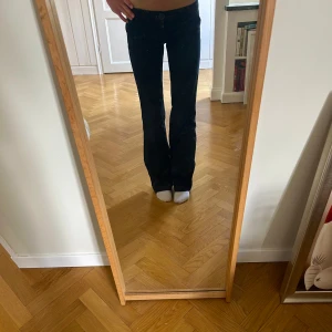 Mörkblå jeansbyxor från Replay - Sjukt snygga och unika jeans från Replay med raka ben och klassiska bakfickor med knappar. Byxorna har medelhögmidja. 