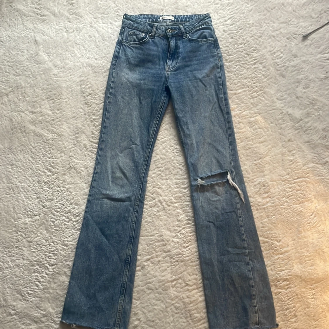 Blå jeansbyxor med hål