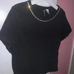 H&M crop top, strl xs - nyskick - En svart crop top med stenar från H&M i storlek xs. Nyskick, aldrig använd. Levereras nytvättad. Postar samma dag som betalning gjorts! Om du har några frågor får du gärna höra av dig. Mvh