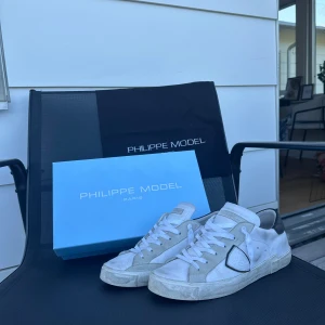 Philipe model  - Säljer nu mina Philipe Models då det tyvärr blivit försmå för mig.. Det är ett par klassiska vita snygga skor med svarta detaljer, 100% äkta‼️Köpta i Febuari och har använts flitigt utan några skador, däremot finns det tecken på användning. Dem är storlek 40 men passar 41‼️Kvitto box samt dutchbag medföljer vid köp‼️ Pris är ej hugget i sten och vid snabb affär så kan det sänkas👍Kontaka mig gärna vid frågor och andra tankar.