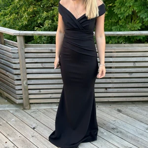 Svart balklänning med offshoulder - Svart balklänning som är offshoulder. Klänningen har figurnära passform. Endast använd 1 gång. 