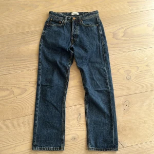 Mörkblå raka jeansbyxor - Klassiska mörkblå jeans med raka ben och femficksdesign. Byxorna har normal passform och stängs med dragkedja och knapp. Perfekta för en avslappnad stil och passar till det mesta.