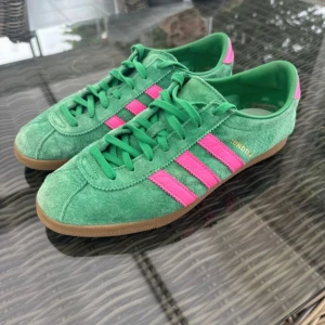 Adidas Originals London gröna sneakers - Säljer dessa Adidas London gröna/rosa. Stl. 40 och 2/3 (7 i UK). Använda 2-3 ggr och säljer för de är för stora för mig. Se bild för serienumret och qr för äkthetsbevis. 