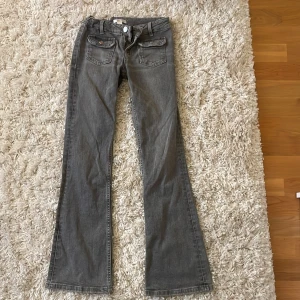 Gråa jeans  - Säljer ett par gråa jeans från Gina Tricot i storlek 152. Byxorna är bootcut och är low waist med klassiska fickor där fram med lock och knappdetaljer. Perfekta för dig som gillar en enkel och stilren look. Pris kan diskuteras.💗Orginalpris 350kr